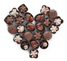 Heart shape composition of chocolate candies on white background