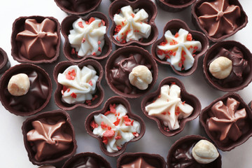 Composition of chocolate candies on white background, close up
