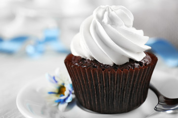 Delicious chocolate cupcake with cream on decorated wooden  table, close up