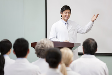 Fototapeta premium Male doctor giving speech in boardroom