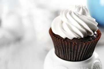 Delicious chocolate cupcake with cream on served table, close up