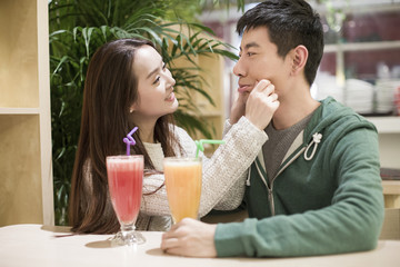 Happy young couple drinking juice