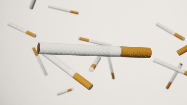 Close up on cigarette floating in space against a white background with a shallow depth of field.