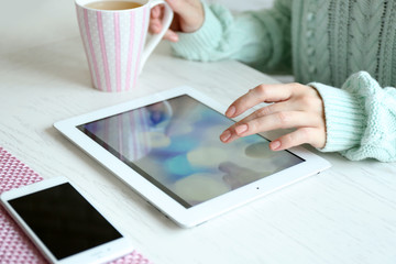 Woman using digital tablet on table close-up