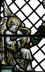 An angel making music (harp) in stained glass