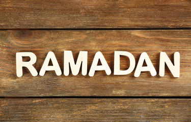 Image of word RAMADAN on wooden background, close up
