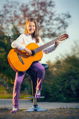 Little Girl Playing Acoustic Guitar Outside
