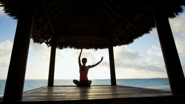 Sunrise silhouette of young girl practicing yoga