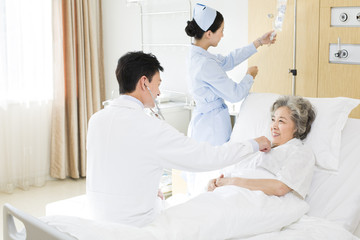 Doctor using stethoscope on patient in hospital