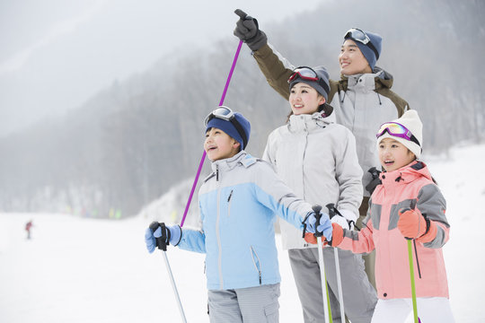 Young Family Skiing In Ski Resort