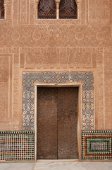 The wall and wooden door with details of islamic calligraphy