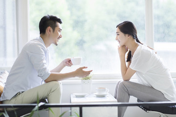 Obraz premium Happy young couple drinking coffee in coffee shop