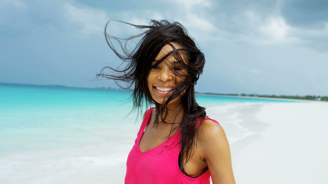 Portrait of African American girl walking on ocean sand 
