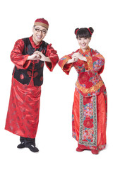 Young couple in traditional Chinese clothing greeting for Chinese New Year