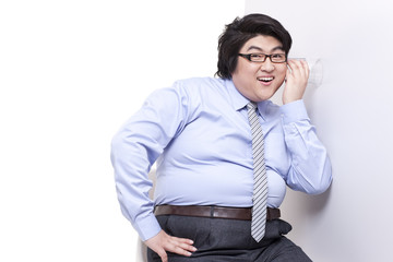 Overweight businessman doing eavesdropping