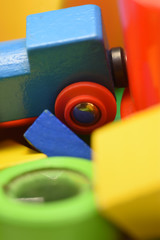 Blue Wooden Toy Train Among A Pile Of Brightly Coloured Plastic and Wooden Toys in Close-Up