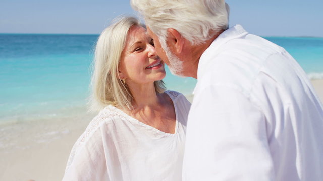 Romantic senior Caucasian couple dancing on a beach