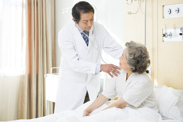 Obraz premium Doctor using stethoscope on patient in hospital