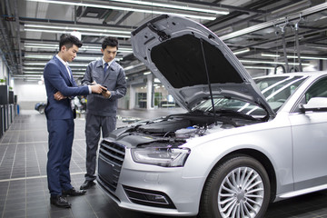 Auto mechanic talking with car owner
