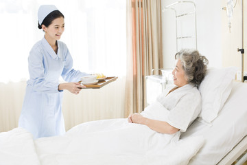 Nurse preparing food for senior patient