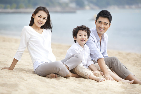Happy young family relaxing themselves on the beach of Repulse Bay, Hong Kong