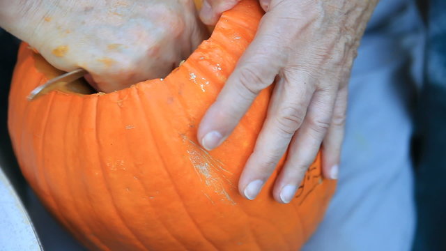 Cleaning out the inside of a pumpkin in preparation for carving a jack o' lantern