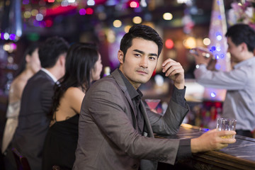 Young man drinking alcohol in bar