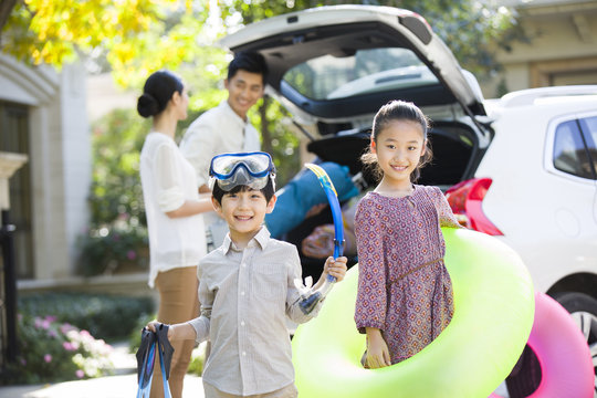 Young family putting water sports equipment into the car