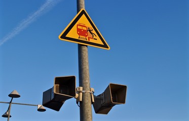 Durchsage Lautsprecher mit gelber Bahn - und Warnschild / Signaltafel