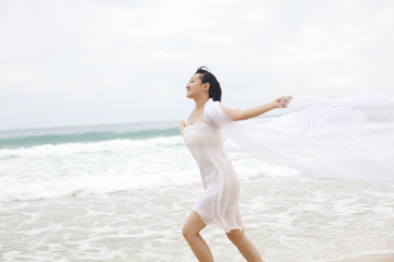 Fototapeta na wymiar Portrait of a young woman running along the beach