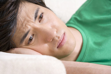 Asian man lying on a sofa