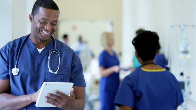 Portrait of African American male nurse working on technology in medical centre