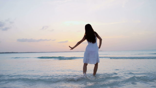 Sexy young Asian Chinese girl with white dress dancing on beach 