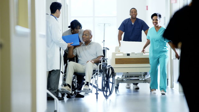 African American disability male on wheelchair and wife in medical centre