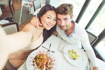 Fotobehang Young couple having romantic lunch in a fancy restaurant © oneinchpunch
