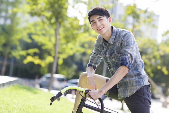 Happy young man riding bicycle