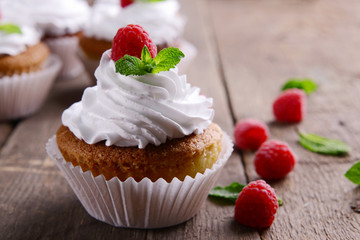 Delicious cupcakes with berries and fresh mint on wooden table close up