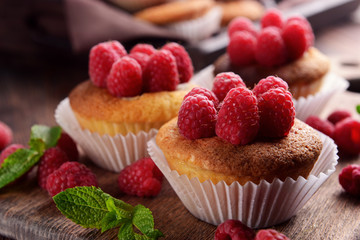 Delicious cupcakes with berries and fresh mint on wooden table close up