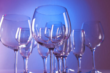 Empty wine glasses on color background