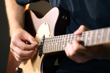 Fototapeta na wymiar Young musician playing acoustic guitar close up