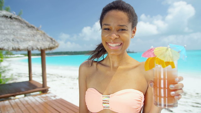 Beautiful African American girl with party cocktail drink on beach