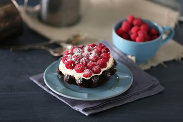 Sweet cakes with raspberries on color wooden background
