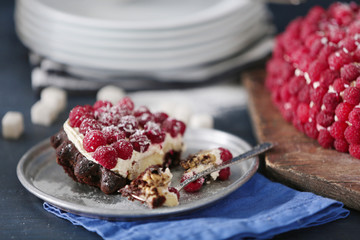Sweet cake with raspberries on color wooden background
