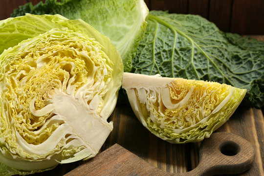 Cut savoy cabbage on wooden cutting board closeup