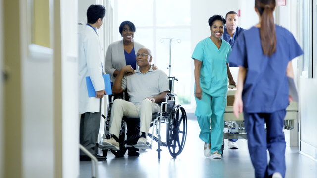African American male disabled and wife consult with doctor in hospital