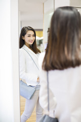 Young woman looking at herself in the mirror