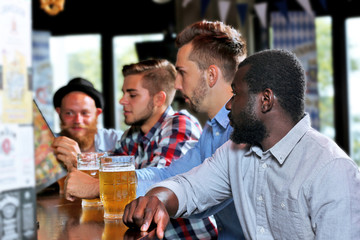 Young men drinking beer in pub