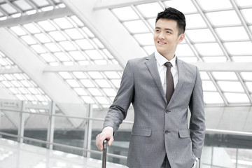 Young businessman at the airport with luggage