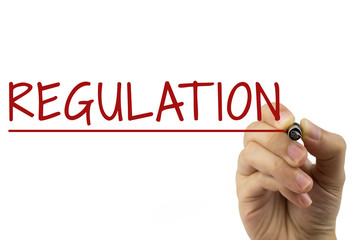 Regulation - Female hand with pen writing text on white background