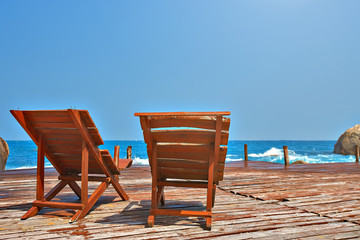 Sun beds on a wooden bridge in the sea 